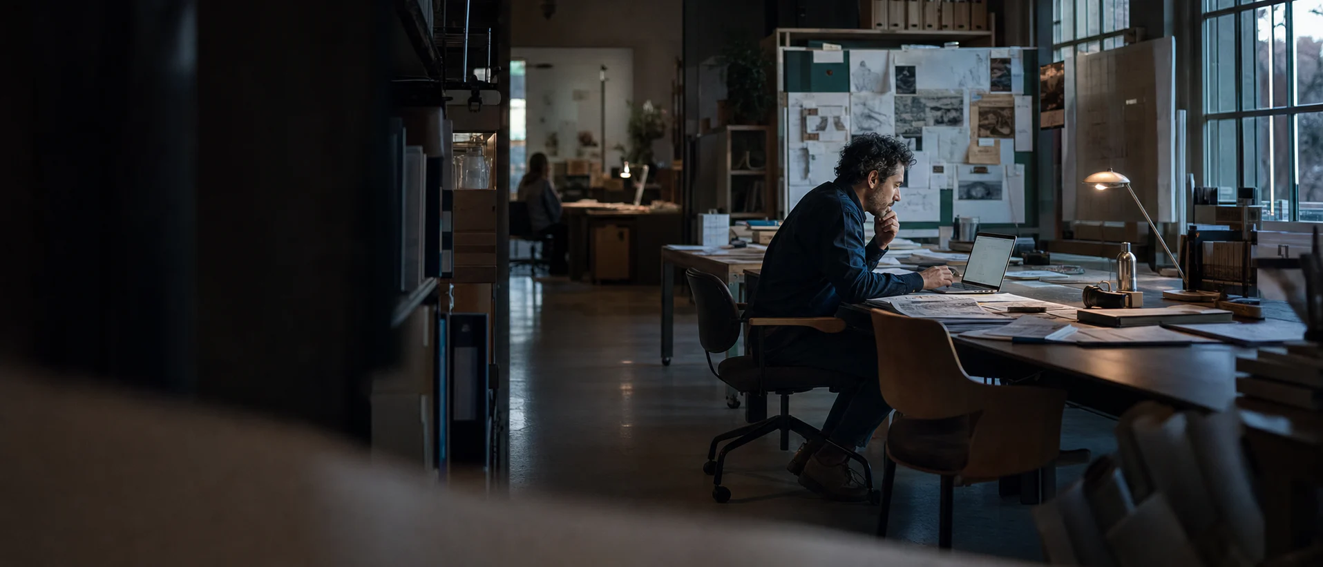 Research analyst working through field notes and data in a shared studio